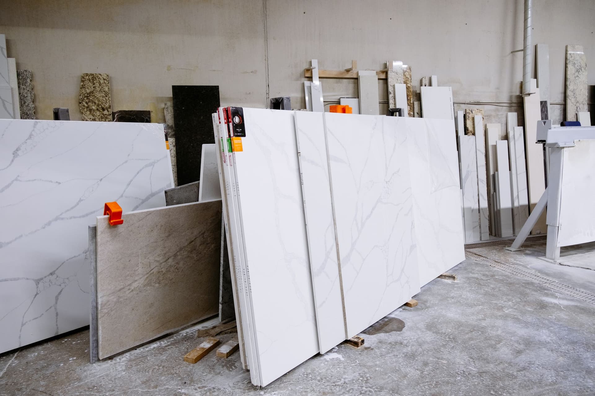 Polished marble and granite slabs stored upright in a stone warehouse.
