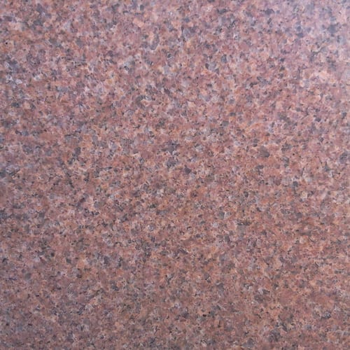 Fersan granite slab face, photographed for the factory catalog — mid-toned red overall.