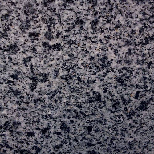 New Halayeb granite slab face, photographed for the factory catalog — deep grey overall.